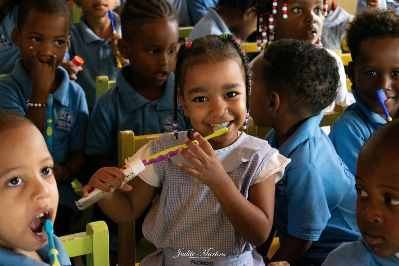Criança a escovar os dentes numa ação de saúde oral em Cabo Verde
