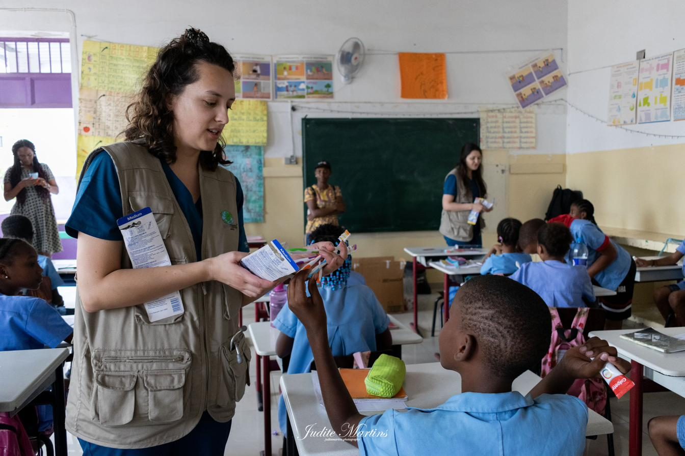 Voluntária a distribuir kits de higiene oral a uma criança