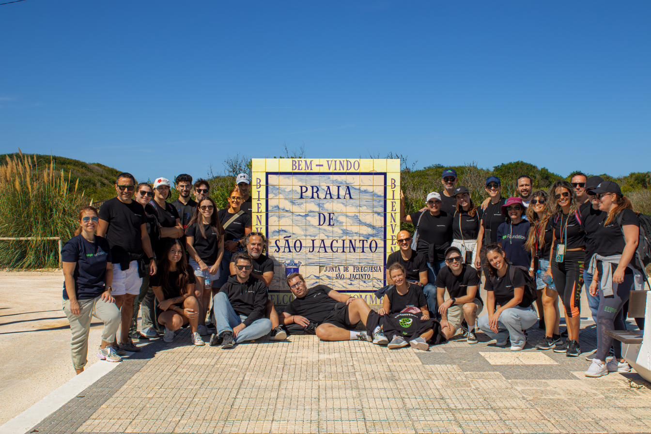 Grupo de voluntários junto ao letreiro da Praia de São Jacinto